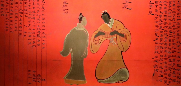 옷칠된 목판에 중국 고대 의상을 입은 두 남자가 서 있는 모습이 그려져 있다. 오른쪽 남자는 죽간을 펼쳐 들고 있다.